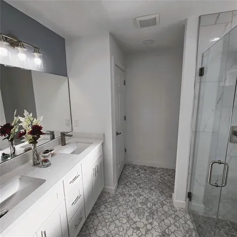 a bathroom with double sink and a mirror