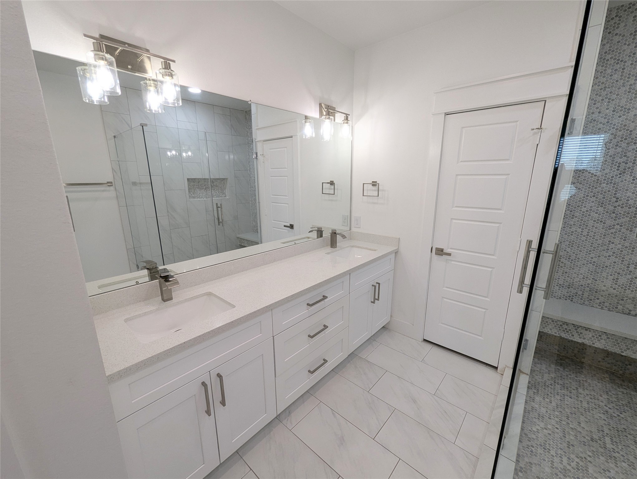 4913 Fisk Street Houston, TX 77009 - Photo 17 of 27 a spacious bathroom with a double vanity sink a mirror and a shower