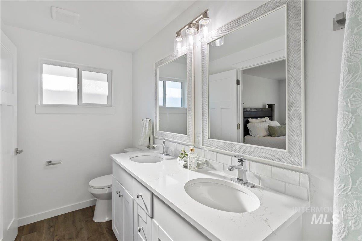 1184 Starfire Street Twin Falls, ID 83301 - Photo 18 of 34 Ensuite bathroom with double vanity, dark wood-style floors, and curtained shower