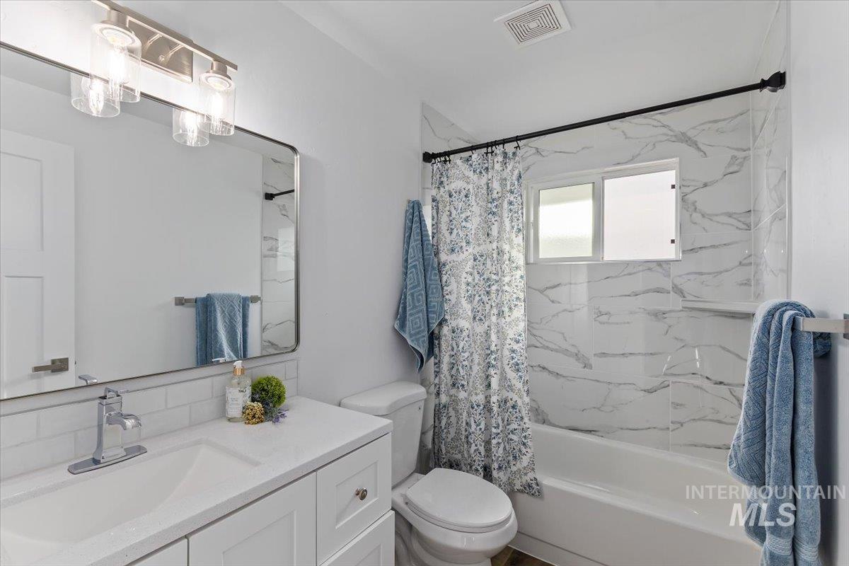 1184 Starfire Street Twin Falls, ID 83301 - Photo 22 of 34 Bathroom with vanity, shower / bathtub combination with curtain, and decorative backsplash