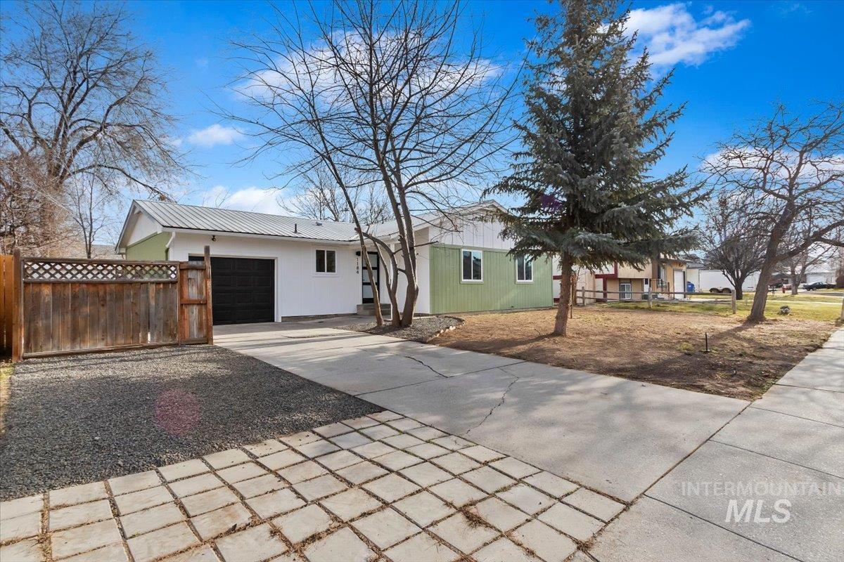 1184 Starfire Street Twin Falls, ID 83301 - Photo 4 of 34 Single story home featuring a garage, driveway, and a metal roof