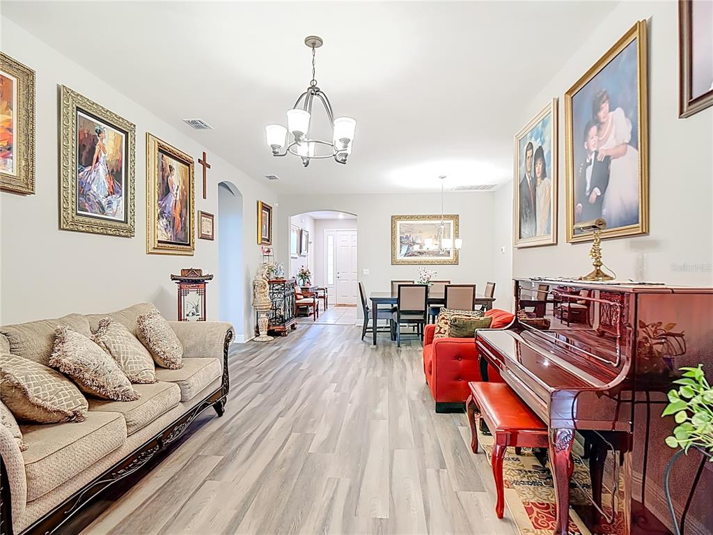 237 Walkers Point Drive Auburndale, FL 33823 - Photo 7 of 31 a living room with furniture kitchen view and a chandelier