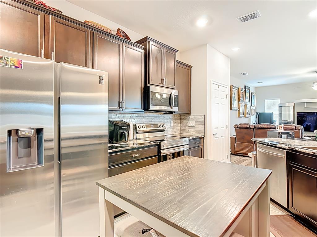 237 Walkers Point Drive Auburndale, FL 33823 - Photo 8 of 31 a kitchen with granite countertop a refrigerator stove top oven and cabinets