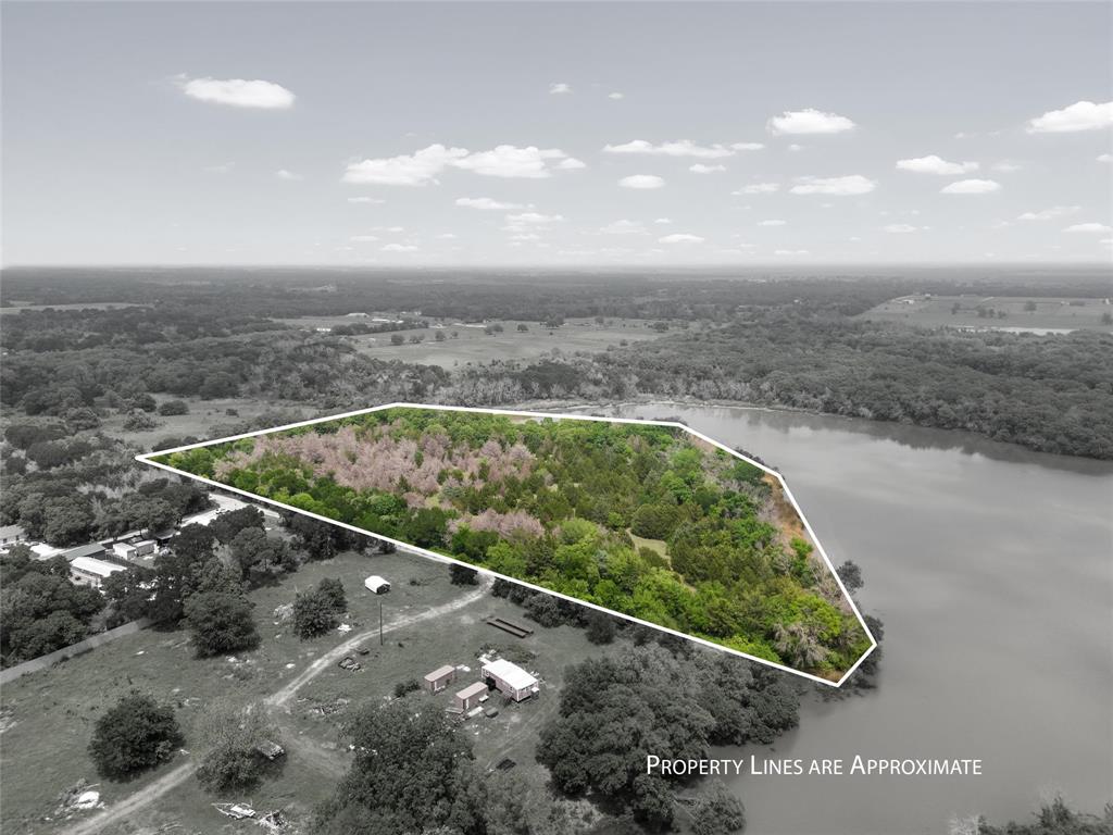 Birds eye view of property with a water view and a wooded view