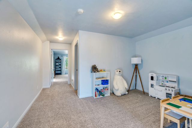 1727 South Sandhill Road Orem, UT 84058 - Photo 22 of 27 Carpeted room with light-toned walls and ceiling, featuring recessed lighting and a doorway opening to a hallway