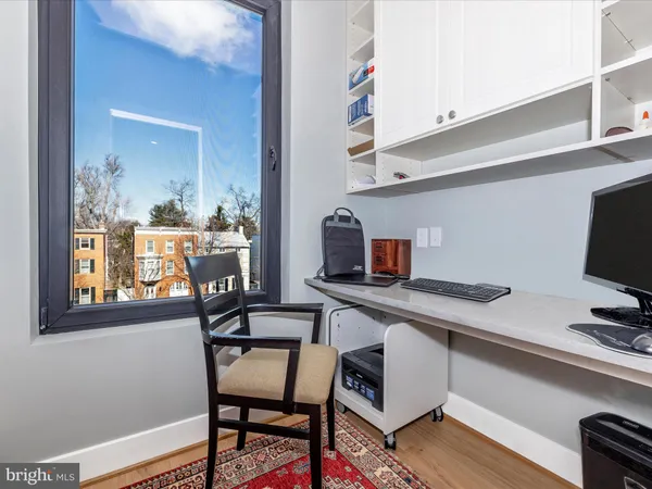 a view of a workspace with furniture and wooden floor