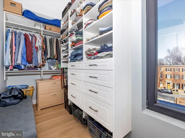 a view of walk in closet with clothes and shoes