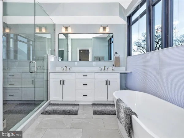 a bathroom with a tub sink and mirror