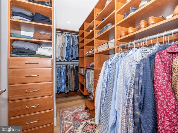 a view of walk in closet with clothes and shoes