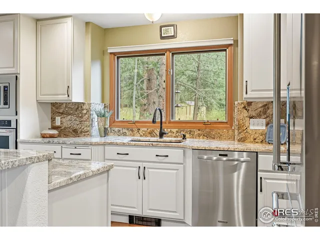 a kitchen with stainless steel appliances granite countertop a sink a stove a refrigerator and island with wooden floor