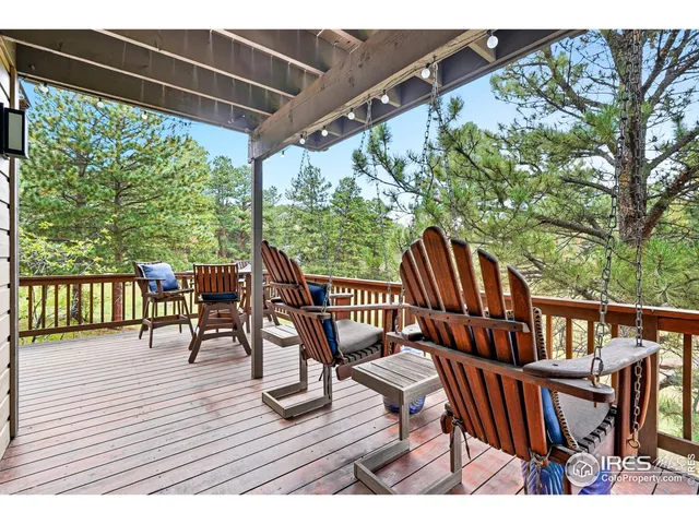 a view of a patio with table and chairs with wooden floor and fence
