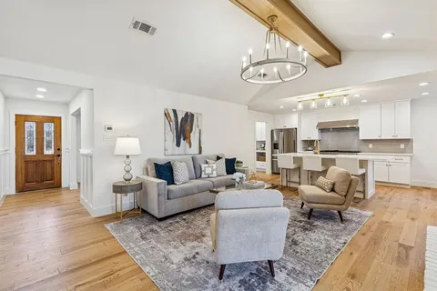 a living room with furniture kitchen and a chandelier