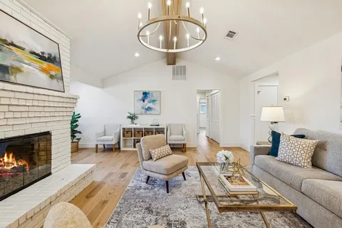a living room with furniture a chandelier and a fireplace