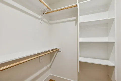 a view of walk in closet with empty racks