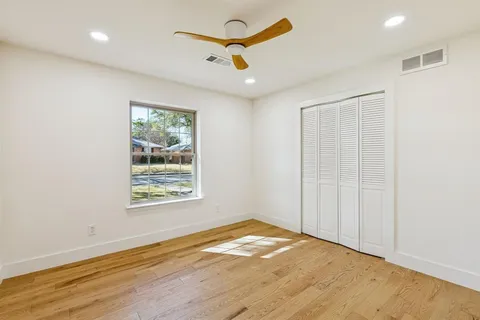 an empty room with a window and a ceiling fan
