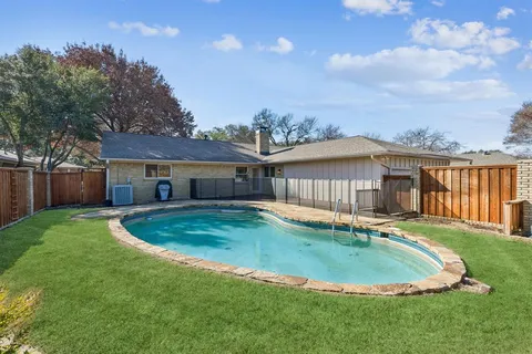 a view of house with backyard and pool