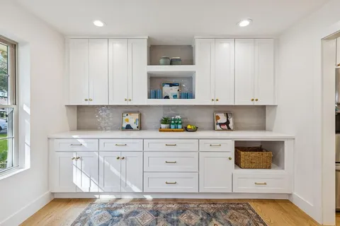 a kitchen with stainless steel appliances granite countertop a stove a sink and a white cabinets
