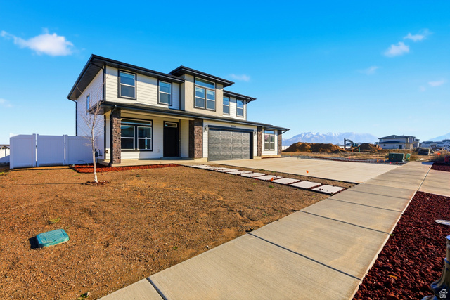 3902 West 825 North West Point, UT 84015 - Photo 6 of 49 View of front of house with an attached garage, driveway, a mountain view, and a porch