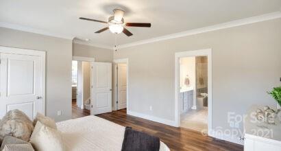 3409 Sincerity Road, Unit 15 Monroe, NC 28110 - Photo 23 of 32 a bedroom with a large bed and a chandelier