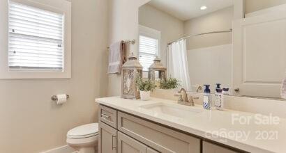 3409 Sincerity Road, Unit 15 Monroe, NC 28110 - Photo 4 of 32 a bathroom with a granite countertop sink a toilet and a mirror