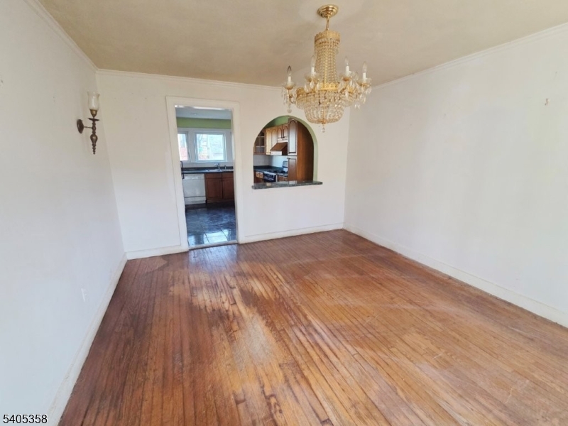 377 Lum Avenue Union, NJ 07083 - Photo 6 of 13 an empty room with wooden floor chandelier and entryway