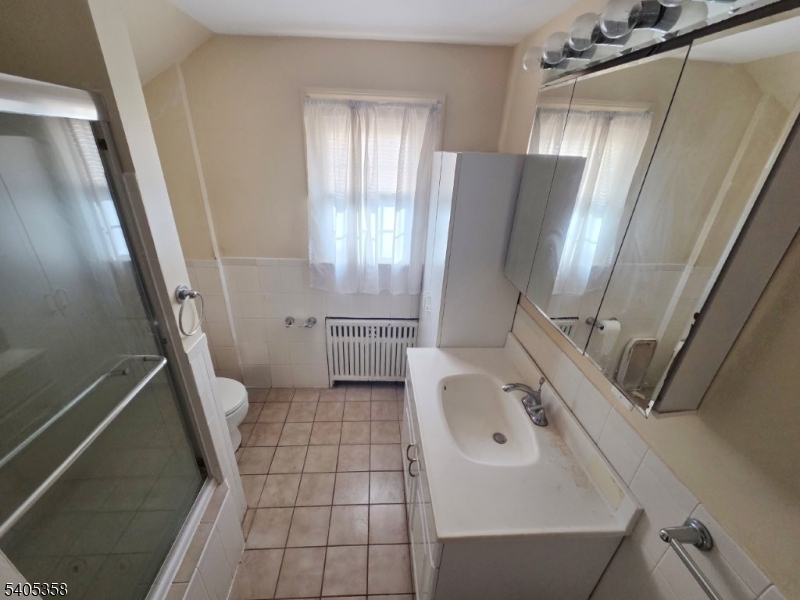 377 Lum Avenue Union, NJ 07083 - Photo 7 of 13 a bathroom with a sink a toilet and a mirror