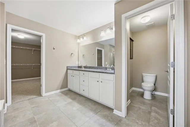 a spacious bathroom with a granite countertop sink toilet and shower
