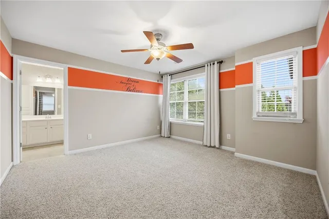 an empty room with windows and ceiling fan