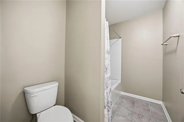 a white toilet sitting next to a shower