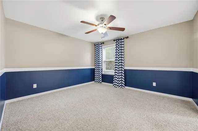a view of an empty room and chandelier fan