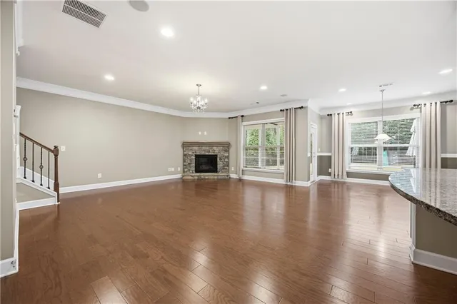 an empty room with wooden floor and outdoor view
