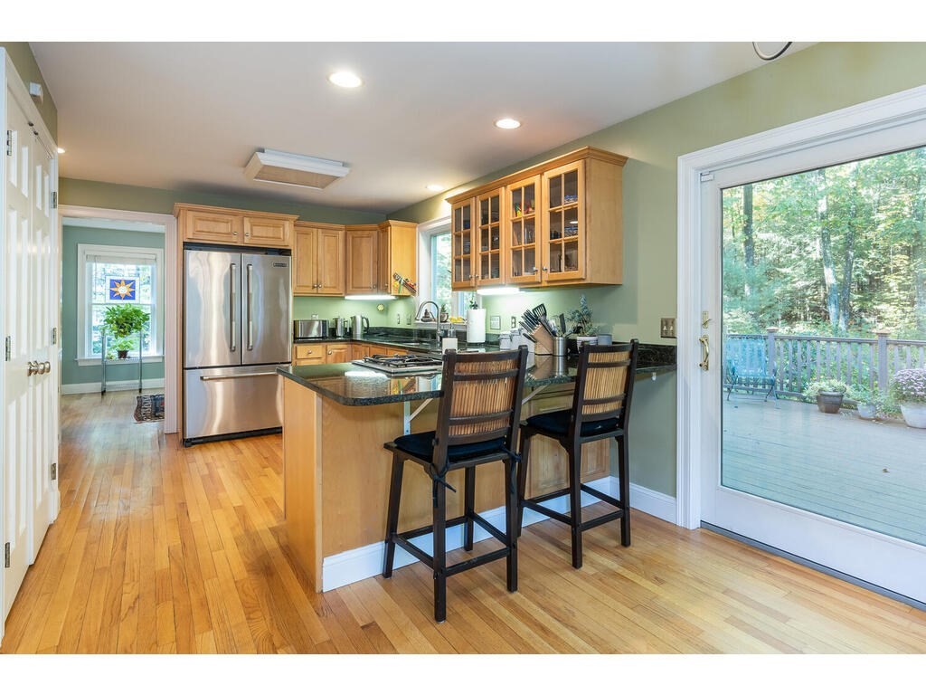 79 Pomeroy Meadow Road Southampton, MA 01073 - Photo 17 of 42 a kitchen with stainless steel appliances granite countertop table chairs and a refrigerator