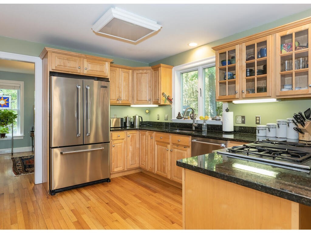 79 Pomeroy Meadow Road Southampton, MA 01073 - Photo 18 of 42 a kitchen with stainless steel appliances granite countertop a refrigerator a sink dishwasher a stove and white countertops with wooden floor
