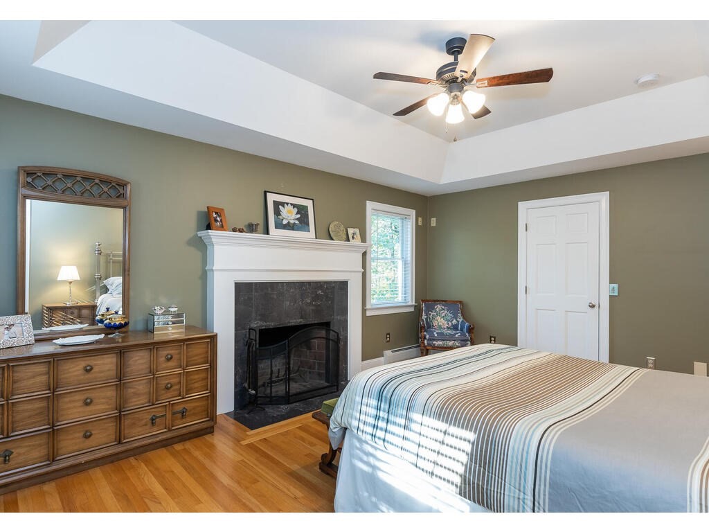 79 Pomeroy Meadow Road Southampton, MA 01073 - Photo 28 of 42 a bedroom with a bed and a fireplace