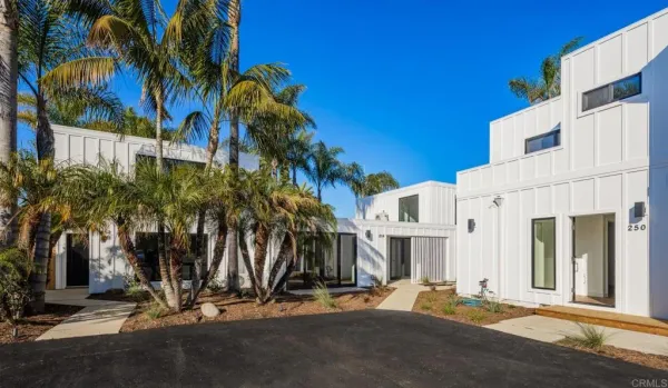 a view of a house with a yard and palm trees