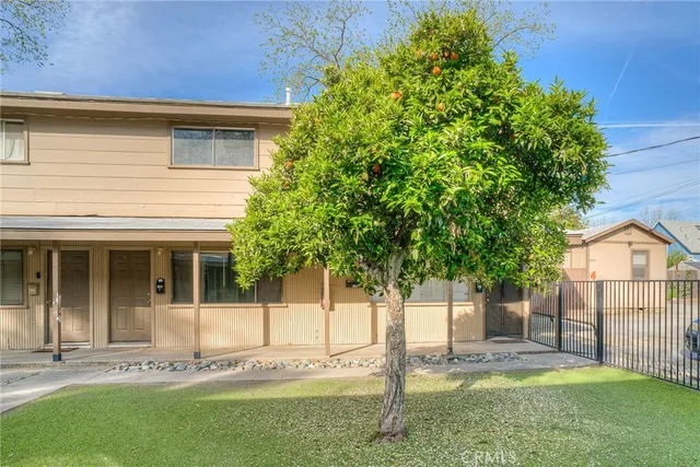 a white house that has tree in front of it