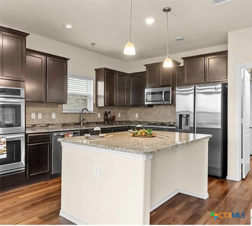 5561 Perdita Drive Belton, TX 76513 - Photo 7 of 24 a kitchen with stainless steel appliances granite countertop a sink refrigerator and microwave