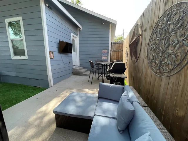 a view of a couches in the patio with a backyard