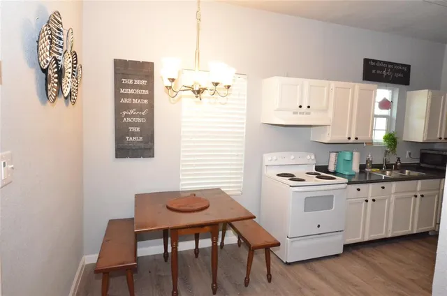 a kitchen with granite countertop a sink cabinets and wooden floor