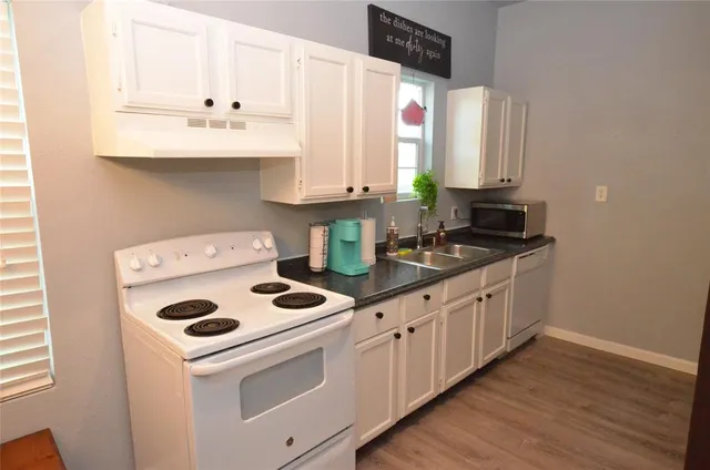 a kitchen with appliances a sink and cabinets