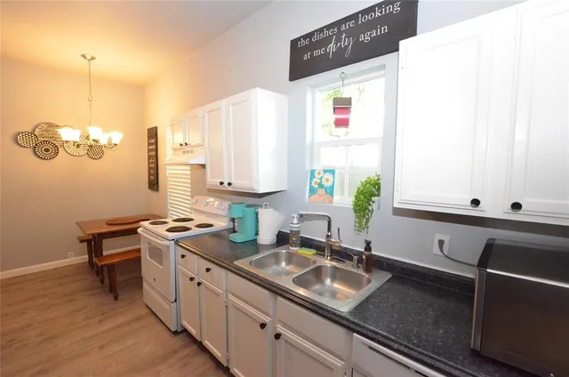 a kitchen with kitchen island granite countertop a sink a counter and a stove