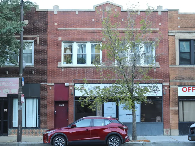 a front view of a building with a garden and plants