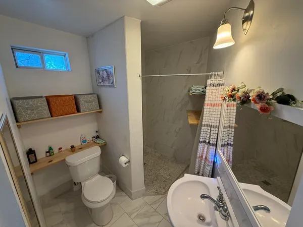 a bathroom with a sink toilet and shower