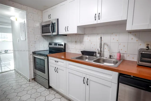 a kitchen with cabinets stainless steel appliances and sink