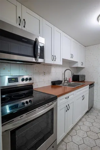 a kitchen with stainless steel appliances granite countertop a stove and a microwave