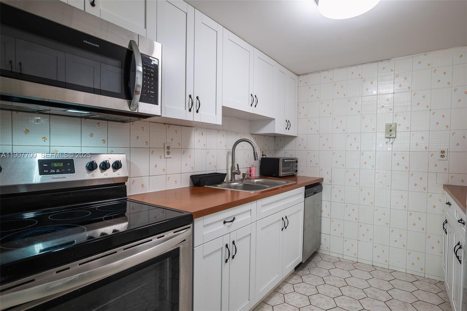 750 Northwest 43rd Avenue, Unit 308 Miami, FL 33126 - Photo 9 of 31 a kitchen with a sink and cabinets