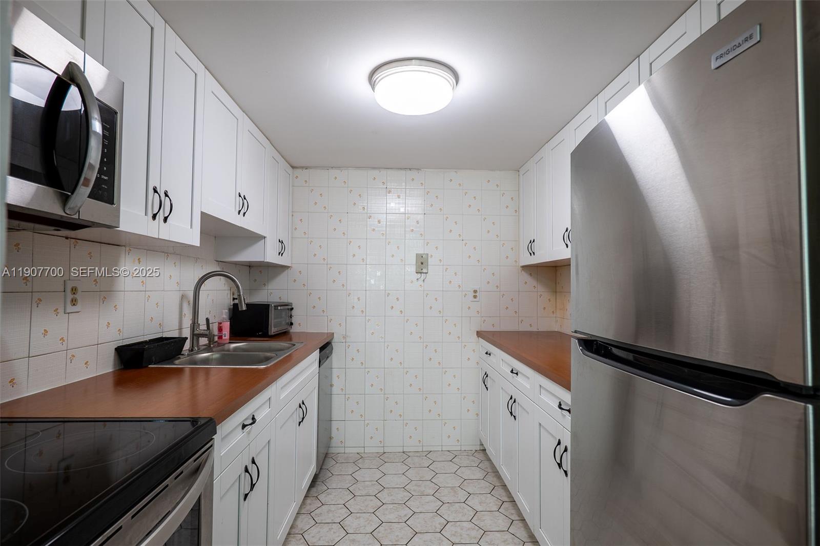 750 Northwest 43rd Avenue, Unit 308 Miami, FL 33126 - Photo 10 of 31 a kitchen with stainless steel appliances a sink a stove and a refrigerator