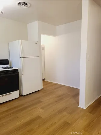 an empty room with a fan & a window