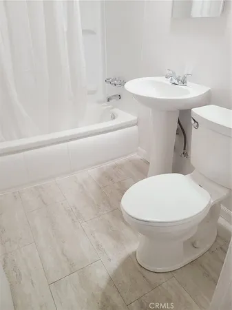a white toilet sitting next to a white sink