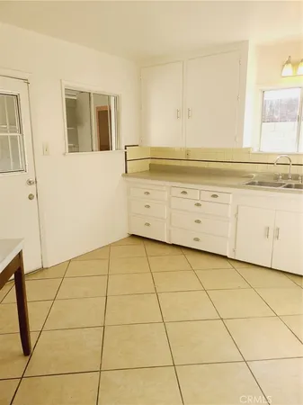 a view of a kitchen with white cabinets and a stove top oven